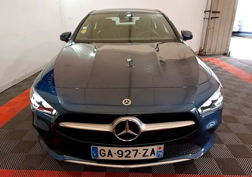 Vue avant d'une Mercedes Classe CLA 180 d Business Line 2021 en bleu foncé avec calandre chromée et phares LED allumés.