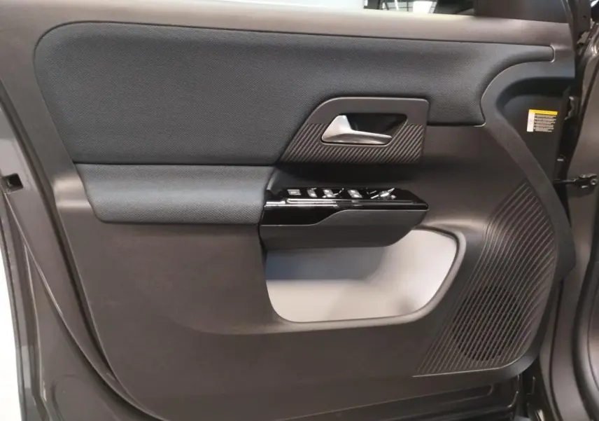 Gros plan sur la porte avant gauche du Citroën C5 Aircross gris platine, avec commandes de vitres et haut-parleur intégrés.