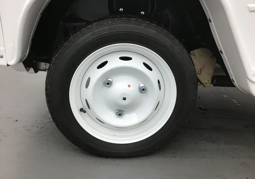 Gros plan sur la roue avant droite blanche du MLT E-STORY ICONE 2024, avec jante acier classique et pneu noir.