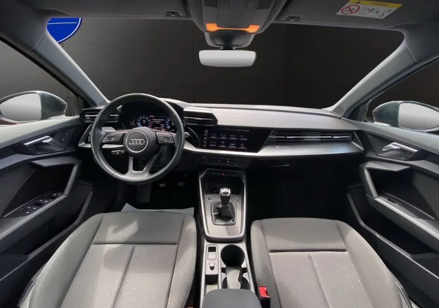 Intérieur noir de l'Audi A3 Sportback 30 TFSI 2021, vue frontale du poste de conduite avec volant et boîte manuelle.