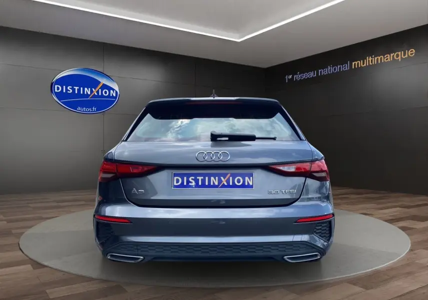 Vue arrière d'une Audi A3 Sportback 30 TFSI gris Daytona avec feux LED et double sortie d'échappement intégrée.