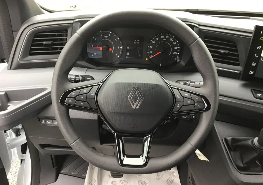 Vue rapprochée du volant noir du Renault Master 2025 avec tableau de bord et commandes intégrées visibles.