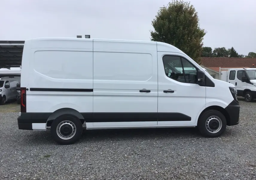 Profil droit d'un utilitaire blanc Renault Master L2H2 2025, avec porte latérale coulissante et jantes acier noires.