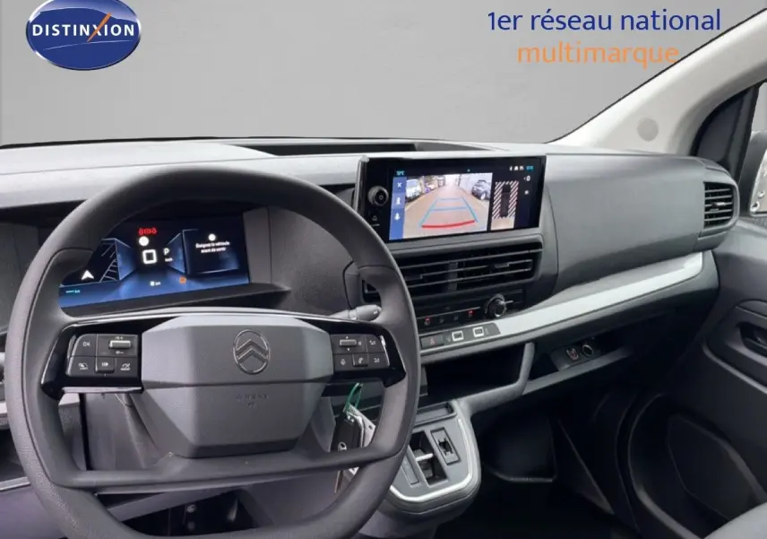 Intérieur du Citroën Jumpy gris, vue du tableau de bord avec volant et écran de caméra de recul visible.
