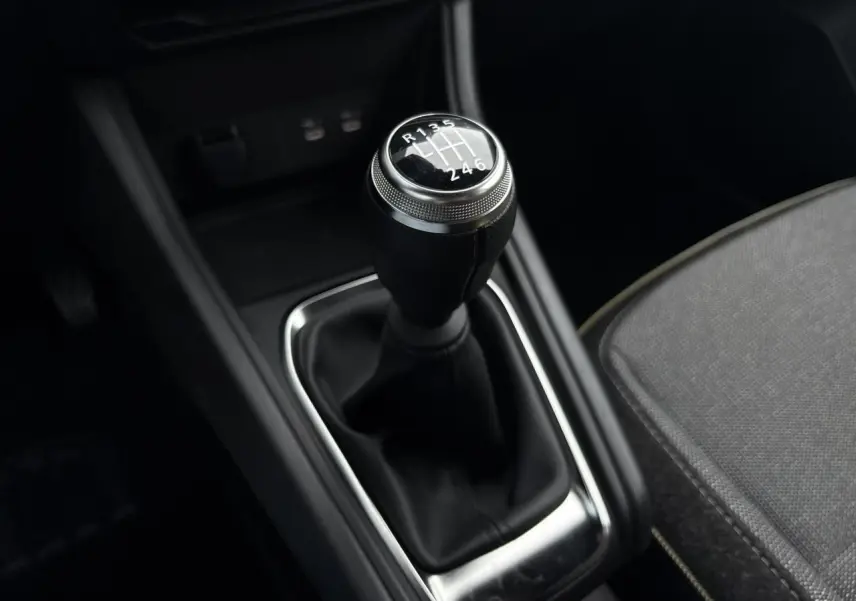 Gros plan sur le levier de vitesses manuel noir du Renault Captur 2025, avec siège gris partiellement visible.