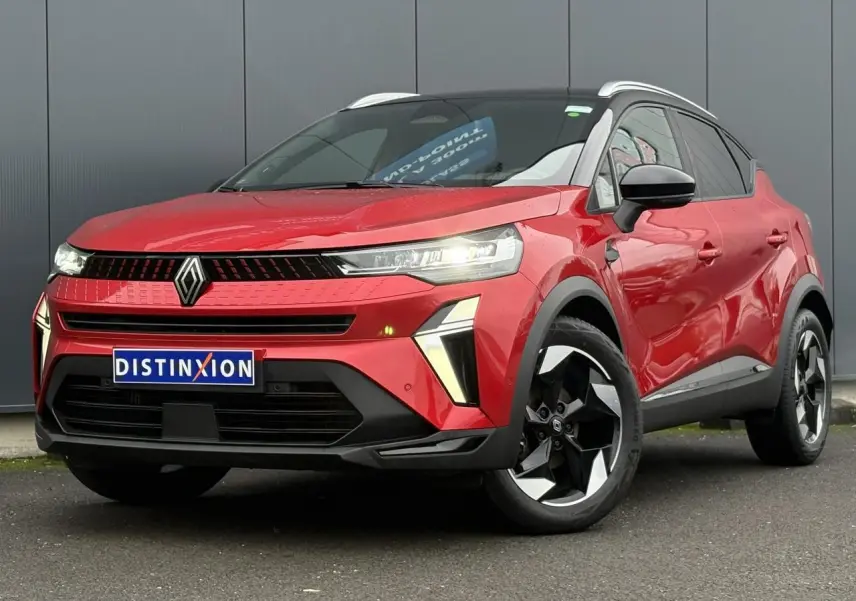 Renault Captur 2025 rouge flamme avec toit noir, vue 3/4 avant, jantes alu diamantées noires et phares LED allumés.