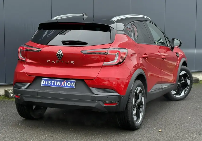 Renault Captur 2025 rouge flamme et toit noir, vue 3/4 arrière droit avec jantes alu noires diamantées.