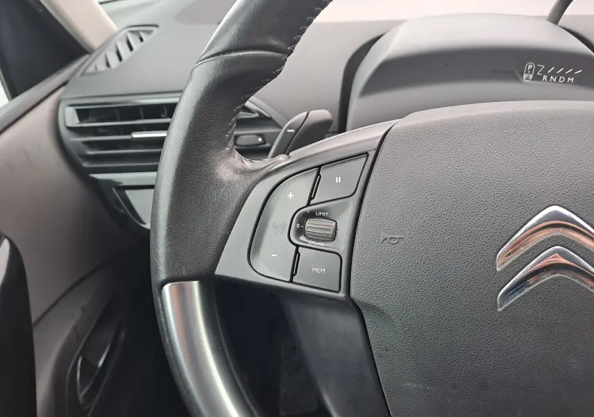 Gros plan sur le volant noir de la Citroën C4 Spacetourer blanc, avec commandes de régulateur de vitesse visibles.