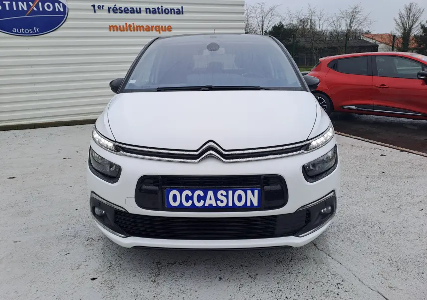 Vue avant d'une Citroën C4 Spacetourer blanche avec plaque "OCCASION" sur un parking extérieur.