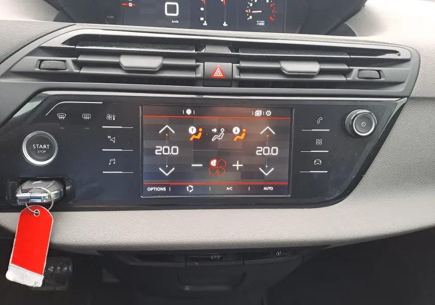 Vue rapprochée du tableau de bord noir du Citroën C4 Spacetourer 2018 avec écran tactile de climatisation et bouton start/stop.