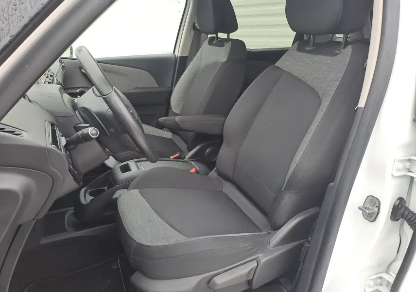 Vue intérieure côté conducteur de la Citroën C4 Spacetourer blanche, sièges tissu bicolore gris et noir, volant visible.