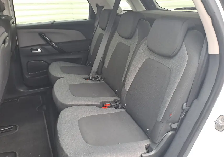 Vue latérale droite de l'intérieur arrière du Citroën C4 Spacetourer blanc, montrant les sièges tissu bicolores gris et noir.