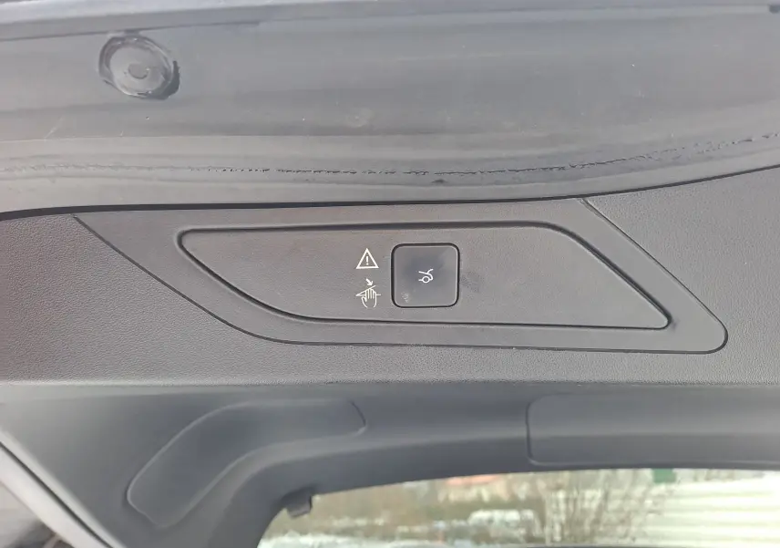 Détail du panneau de commande noir sur le hayon intérieur du Citroën C4 Spacetourer blanc, bouton d'ouverture électrique.