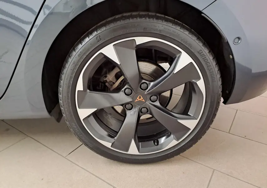 Gros plan sur la roue avant droite de la CUPRA Leon 2023 gris magnétique avec jante alliage bicolore et logo CUPRA central.