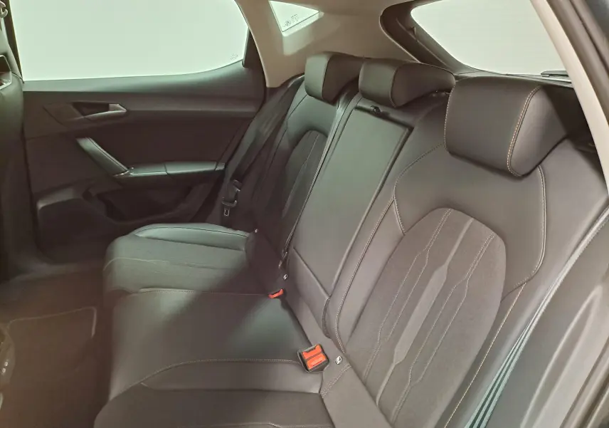 Vue intérieure côté droit des sièges arrière en tissu noir avec surpiqûres orange d'une CUPRA Leon 1.5 TSI 2023 gris magnétique.