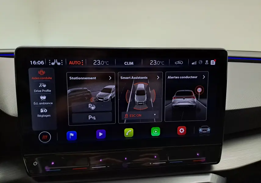 Écran tactile intérieur du tableau de bord de la CUPRA Leon 2023 affichant les aides à la conduite et la climatisation.