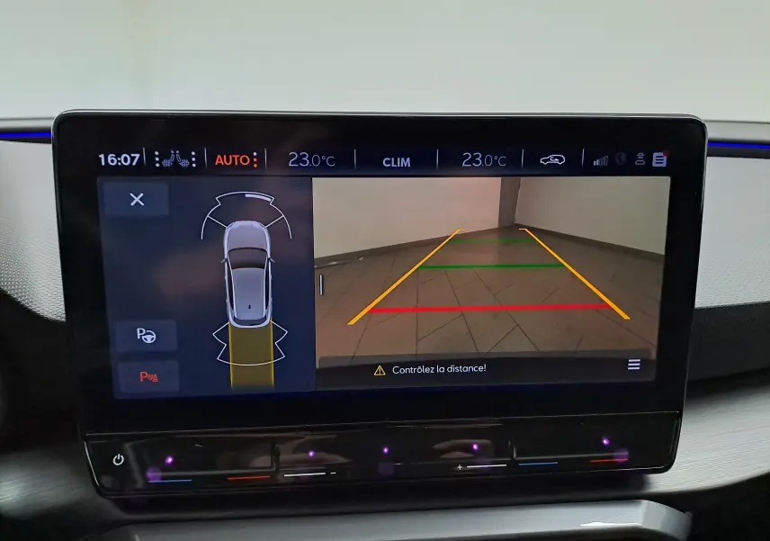 Écran intérieur de la CUPRA Leon 2023 montrant la caméra de recul avec lignes de guidage colorées.
