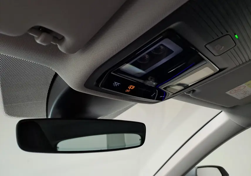 Vue intérieure du plafonnier et du rétroviseur central d’une CUPRA Leon 2023 gris magnétique, avec éclairage et commandes visibles.