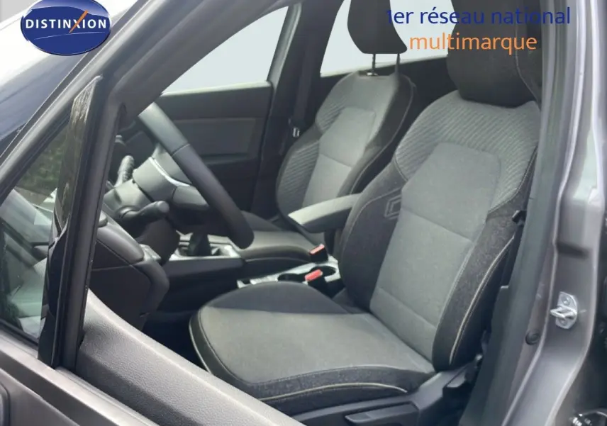 Vue intérieure côté gauche du Renault Captur 2025 gris cassiopée, montrant les sièges avant en tissu gris et noir.