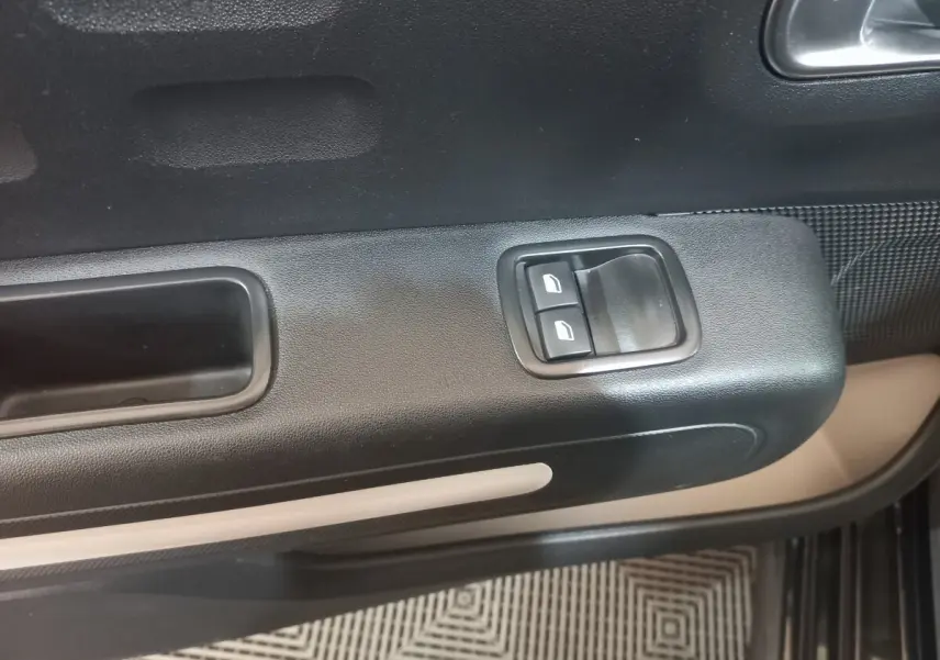 Détail de la porte côté conducteur de la Citroën C3 noire 2024, avec commandes de vitres électriques et poignée intégrée.