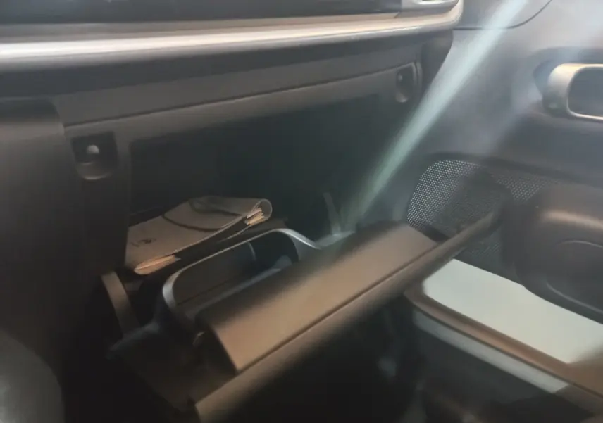 Intérieur de la Citroën C3 2024, vue sur la boîte à gants ouverte côté passager avec rangement et documentation.