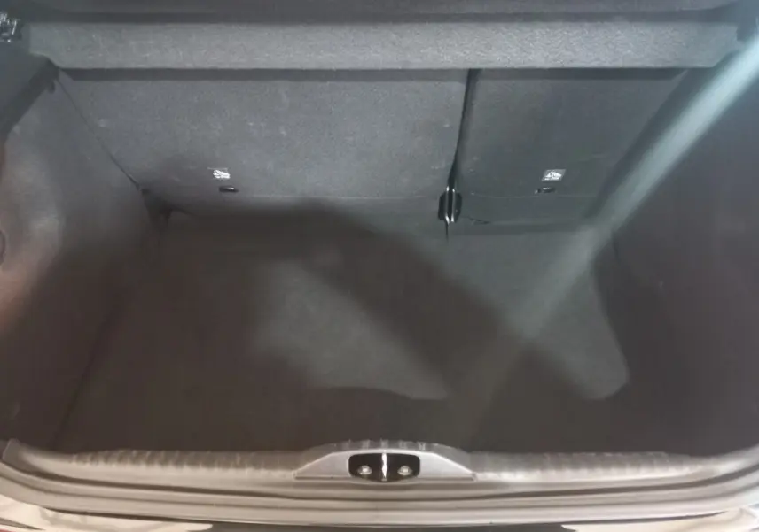 Coffre ouvert vu de dessus de la Citroën C3 noire 2024, montrant l’espace de chargement avec banquette arrière rabattable.