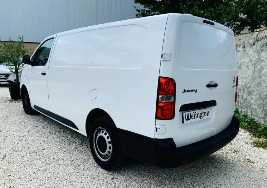Vue 3/4 arrière droite du Citroën Jumpy XL blanc, fourgon utilitaire avec portes battantes arrière et jantes acier.