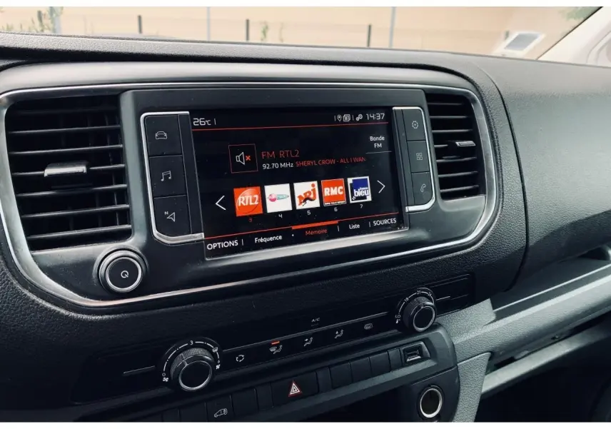 Tableau de bord noir du Citroën Jumpy XL 2020 avec écran tactile affichant les radios FM et commandes de climatisation.