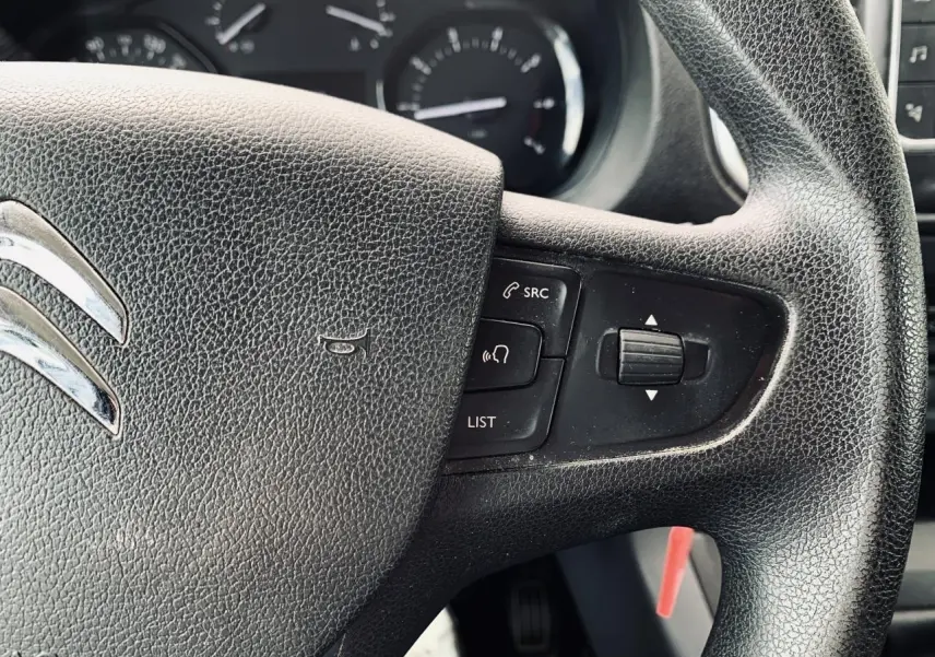 Gros plan sur le volant noir du Citroën Jumpy XL 2020 avec commandes audio intégrées et tableau de bord en arrière-plan.