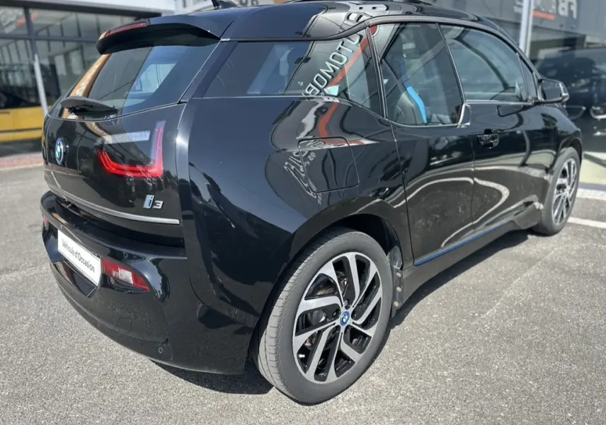 Vue 3/4 arrière droite d'une BMW i3 noire électrique 2022 avec jantes distinctives et vitres teintées.