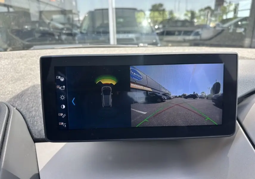 Écran central de BMW i3 2022 noir montrant l'affichage caméra de recul et capteurs de stationnement.