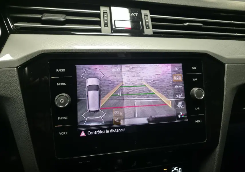 Écran tactile central de la Volkswagen Passat SW gris montrant la caméra de recul avec guidage de stationnement.
