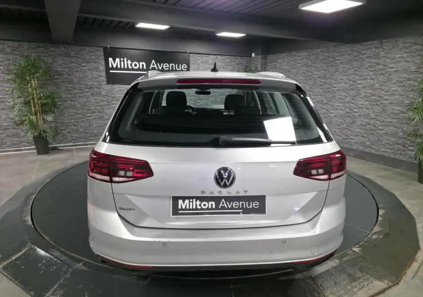 Vue arrière d'un break Volkswagen Passat gris métallisé stationné en intérieur avec éclairage artificiel