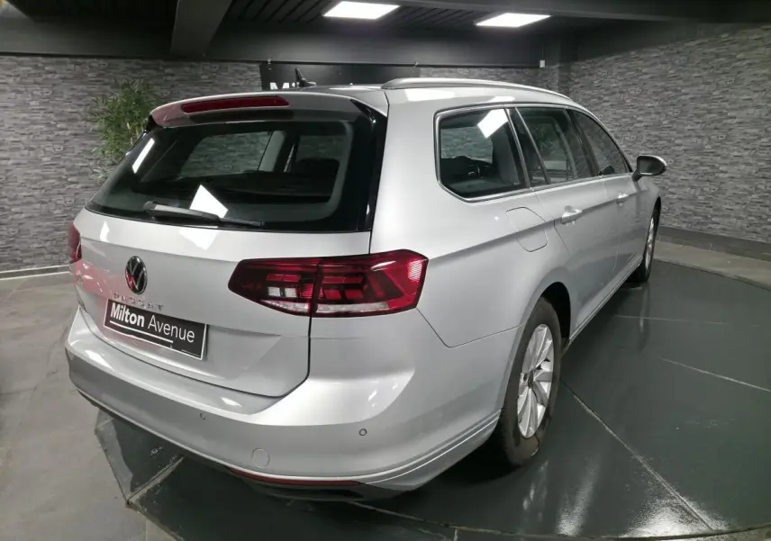 Volkswagen Passat SW gris vue 3/4 arrière droit en intérieur avec feux arrière LED et jantes alliage.