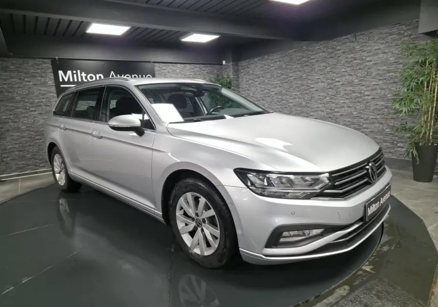 Volkswagen Passat SW gris métallisé vue 3/4 avant droit en intérieur avec éclairage studio et jantes alliage.