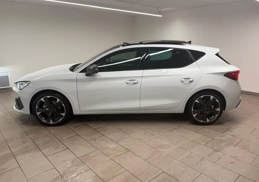 Vue de profil côté gauche d'une CUPRA Leon blanche Nevada avec toit ouvrant panoramique et jantes noires.