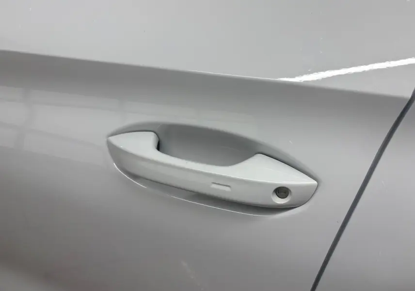 Poignée de porte côté droit de la CUPRA Leon 2024 en blanc Nevada, avec serrure intégrée visible.