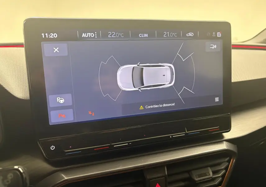 Écran tactile intérieur affichant l'aide au stationnement du CUPRA Leon blanc Nevada avec toit ouvrant panoramique.