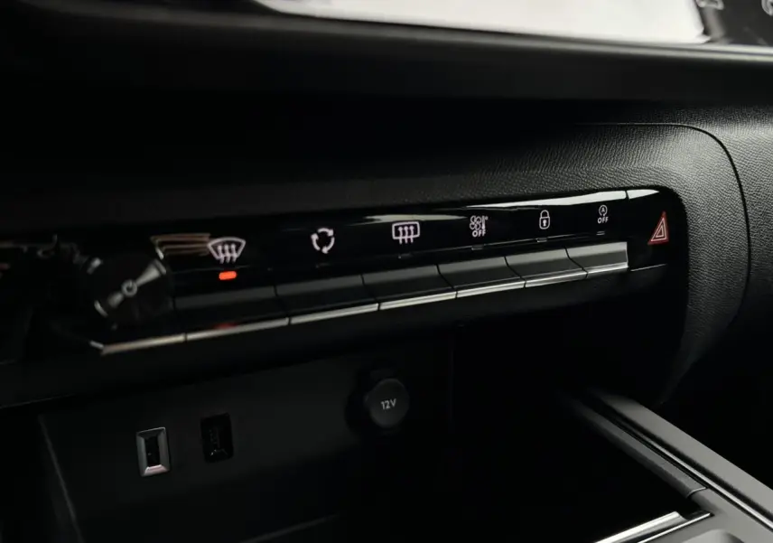 Détail de la console centrale noire du Citroën C5 Aircross 2025 avec boutons de commande et prise 12V visible.