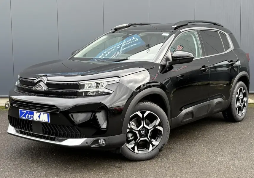 Vue 3/4 avant droite du Citroën C5 Aircross 2025 noir Perla avec jantes diamantées et barres de toit noires.