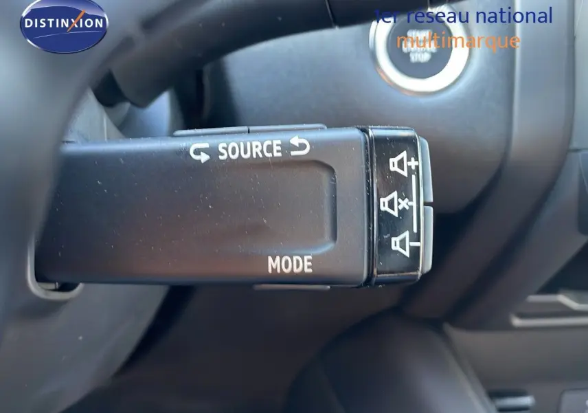 Gros plan sur la commande au volant du Renault Captur E-Tech hybride blanc nacré avec toit gris, modèle 2025.