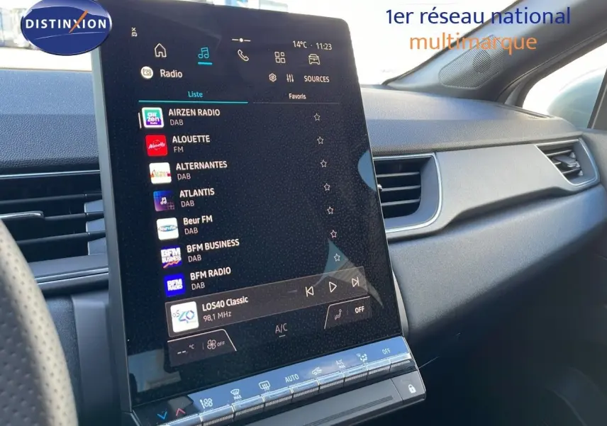 Vue intérieure du tableau de bord du Renault Captur E-Tech blanc nacré, avec écran tactile central affichant les radios DAB.