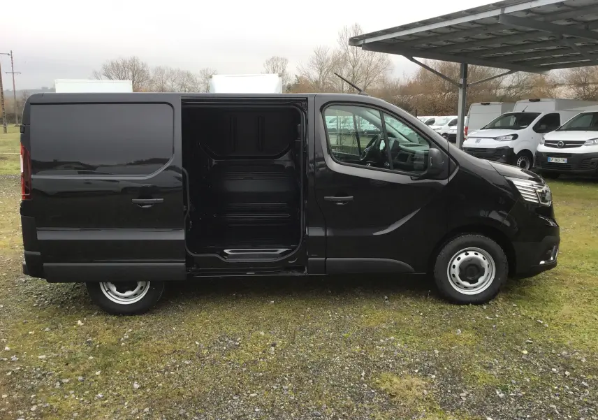 Vue de profil côté gauche d'un Renault Trafic Fourgon noir 2025 avec porte coulissante ouverte révélant l'espace de chargement.