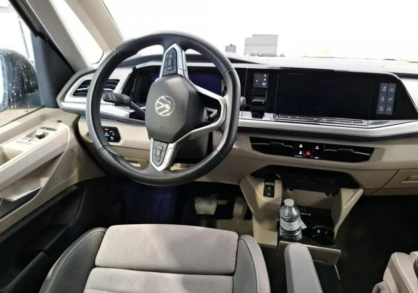 Vue intérieure avant du Volkswagen California T7 2.0 TDI gris, volant cuir multifonctions et tableau de bord numérique.