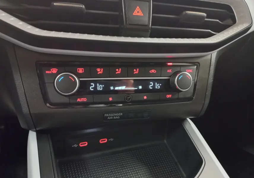 Gros plan sur la console centrale du SEAT Arona 2025, montrant la climatisation digitale et les ports USB.