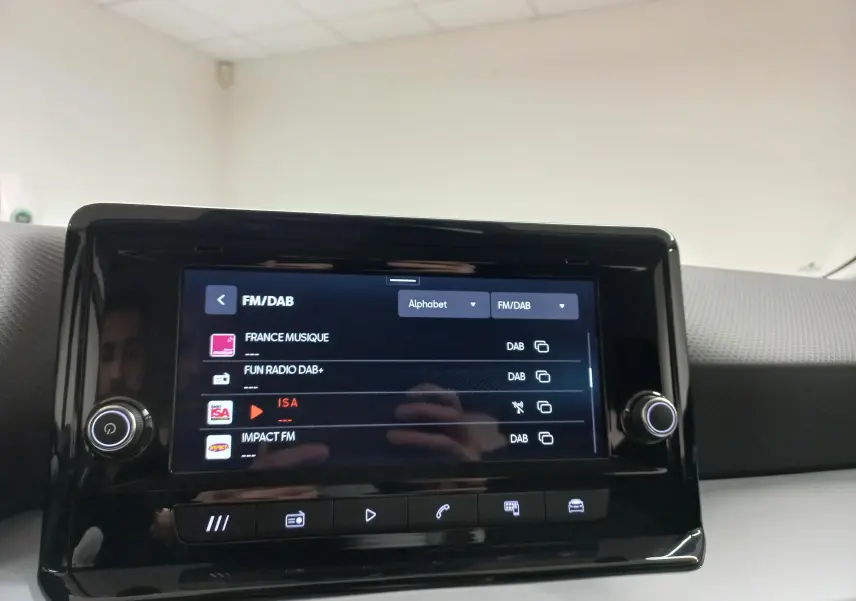 Écran tactile central du tableau de bord du SEAT Arona 2025 affichant les stations FM/DAB, intérieur gris.
