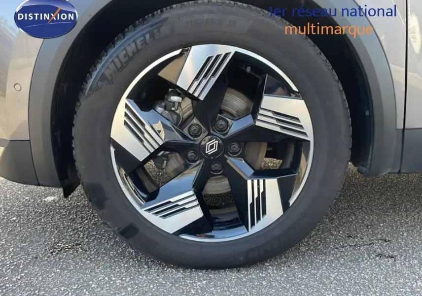 Gros plan sur la roue avant droite de la Renault Symbioz 2025 gris cassiopée métal avec jante noire et argentée au design moderne.