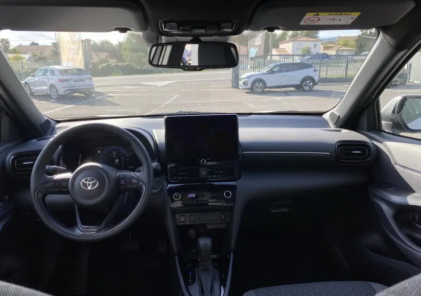 Vue intérieure du tableau de bord et volant cuir noir de la Toyota Yaris Cross 2025 avec écran tactile central.