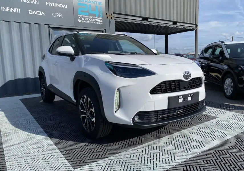 Toyota Yaris Cross blanc pur vue 3/4 avant droit avec jantes alliage et toit noir contrasté.