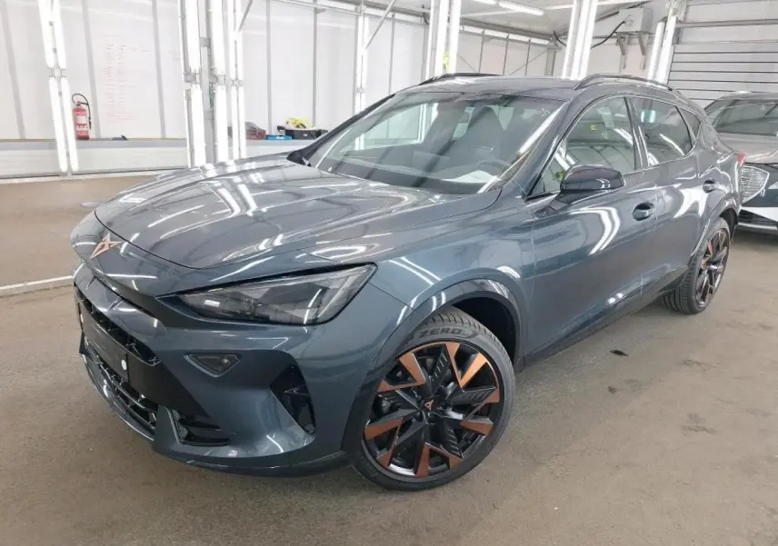 Vue 3/4 avant d'une CUPRA Formentor gris magnétique avec jantes alliage 19'' cuivrées dans un garage.